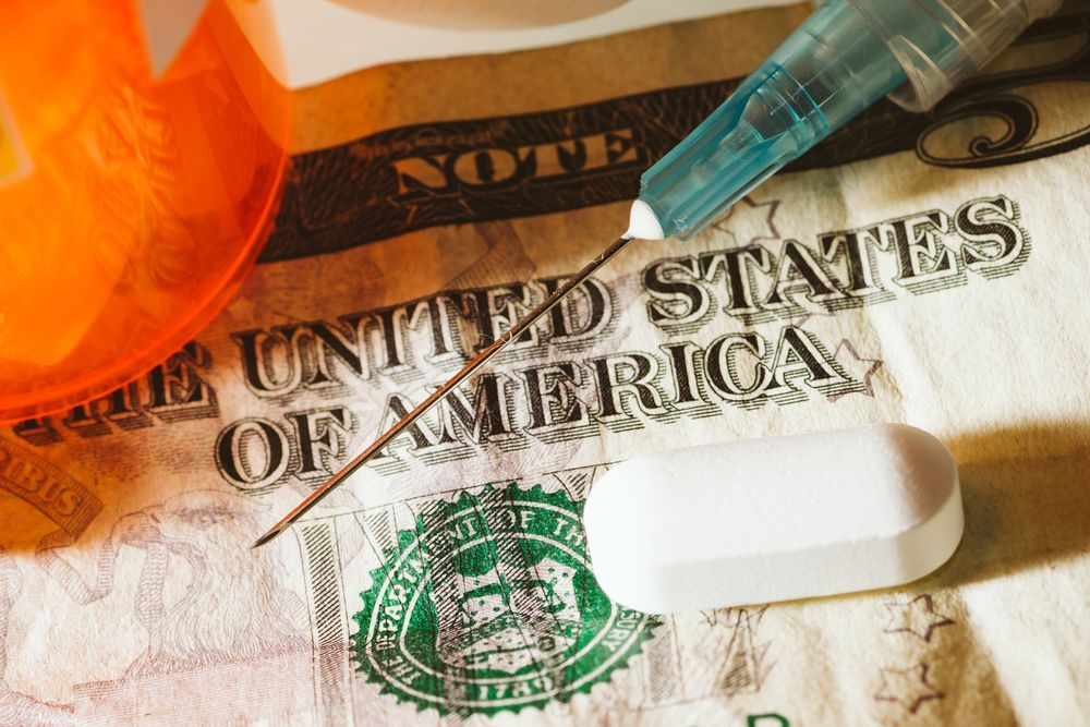 Pills, syringe, dollar bill