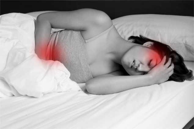 sick woman on bed concept of stomachache, menstrual cramp, headache, hangover