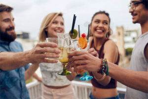 Friends having fun and drinking cocktails outdoor on a rooftop get together