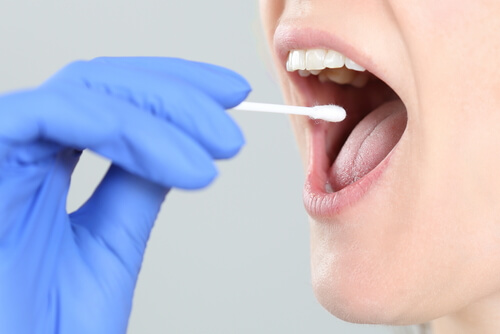 doctor taking a mouth swab for a saliva drug test