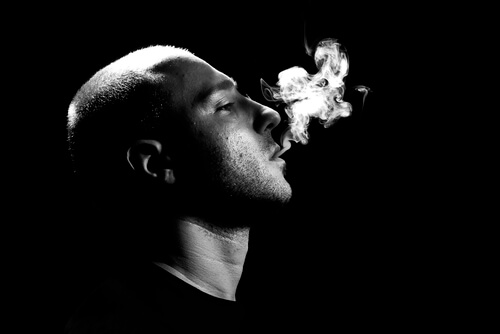 man exhaling the smoke