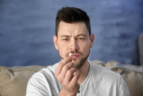 young man looking at the pill