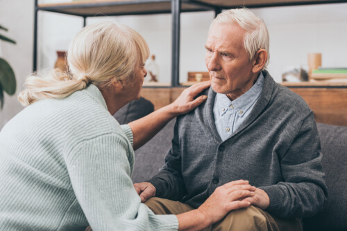 Aged couple holding hands and looking each other