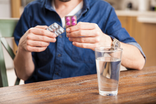 man holding benadryl and zyrtec blisters