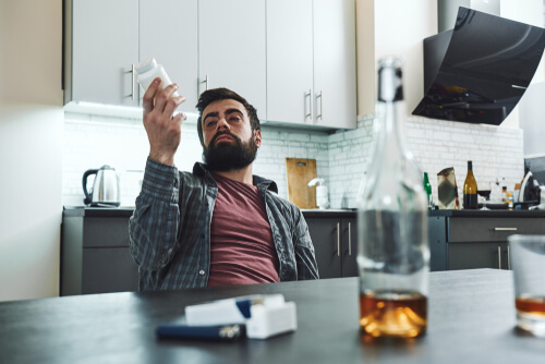 man drinking alcohol with pills