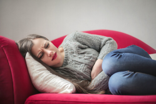 Woman Lies On A Couch With Abdominal Pain
