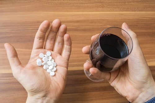Pílulas de prescrição e copo de vinho