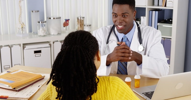 African American woman patient speaking with doctor.