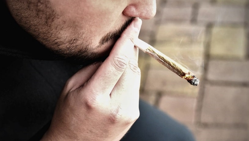 Man smoking cannabis joint.