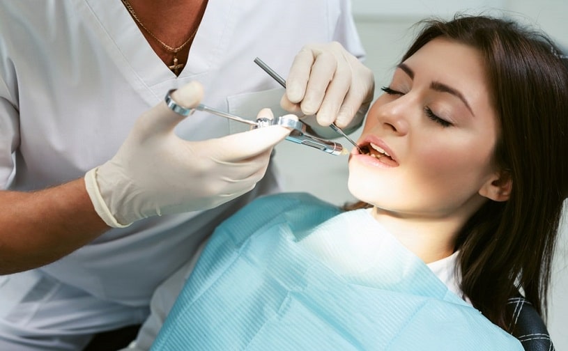Dentist treating woman's teeth.