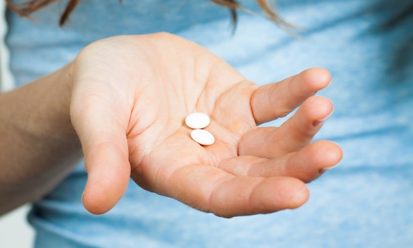 Woman hands with Adderall pills.