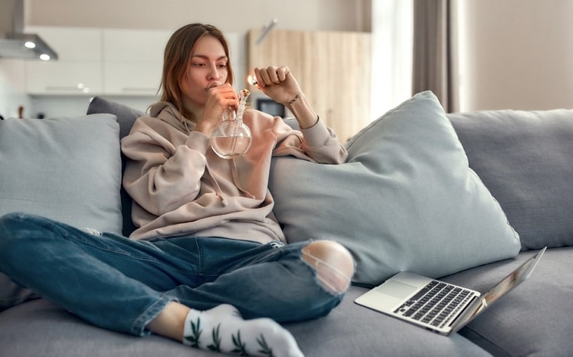 Pregnant woman smoking cannabis at home.