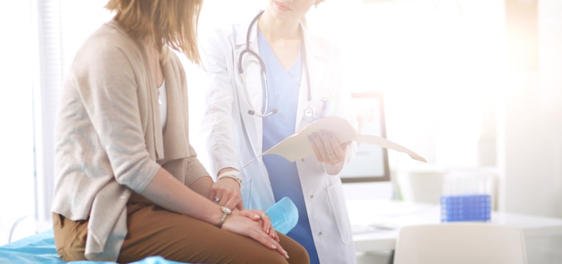 The doctor calms the patient with a touch of his hand.