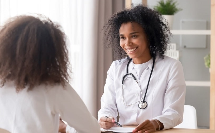 african american female doctor talks with patient.
