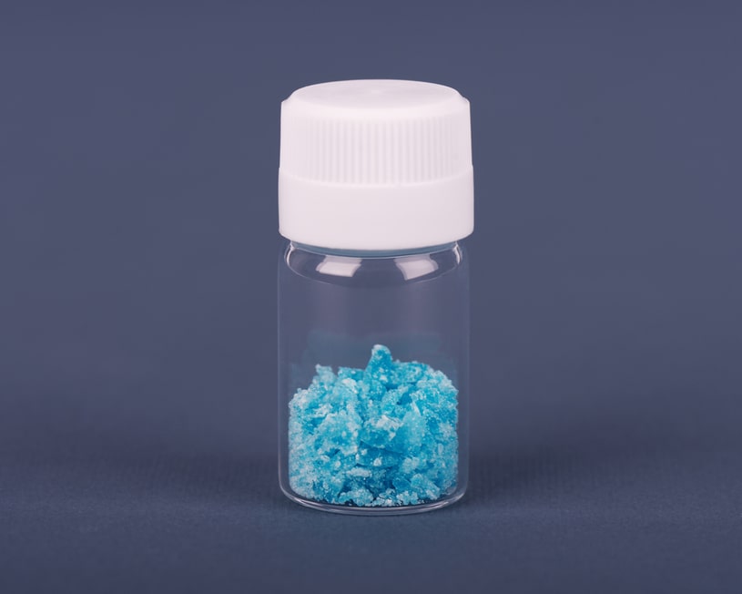  Blue crystals of bath salt in a glass jar.