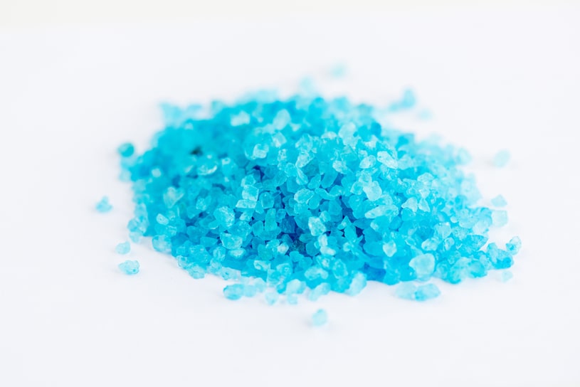 Blue bath salts lies on a white background.
