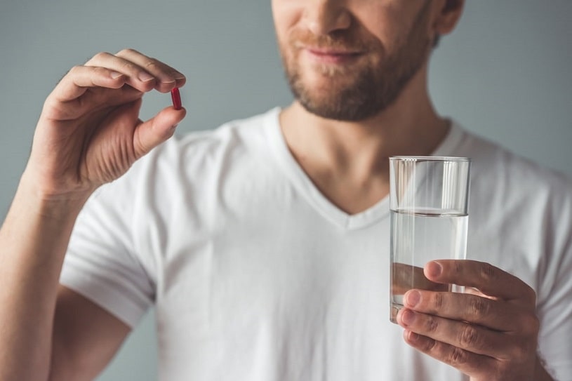 Man holding Vicodin pill.