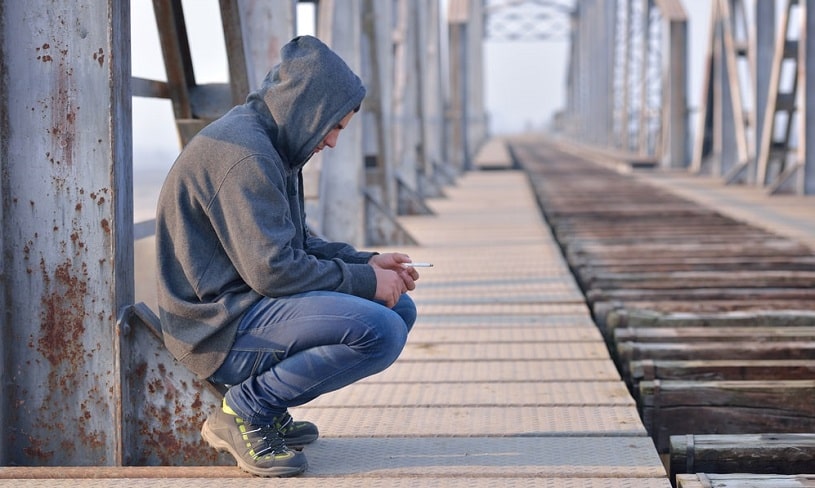 Heroin addict sitting alone and depressed.