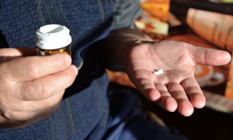 Man poured the pills into hand.