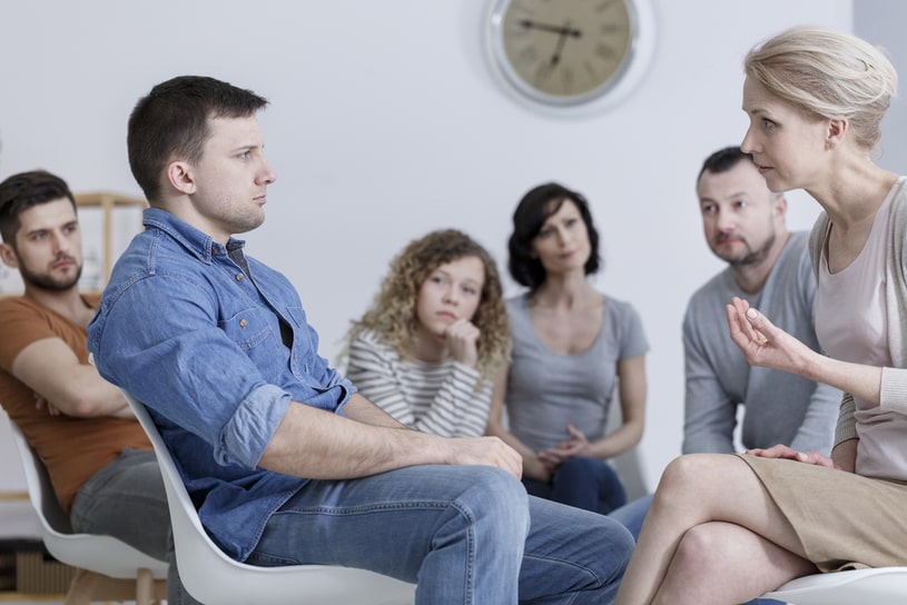 Addicts support group, a woman talking to a man.