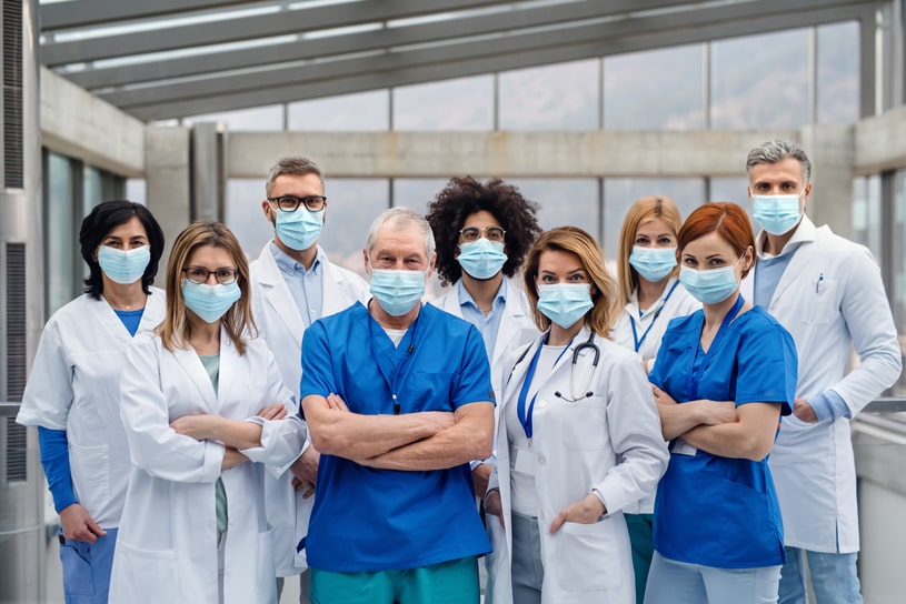 A team of doctors stands in the center of the room.