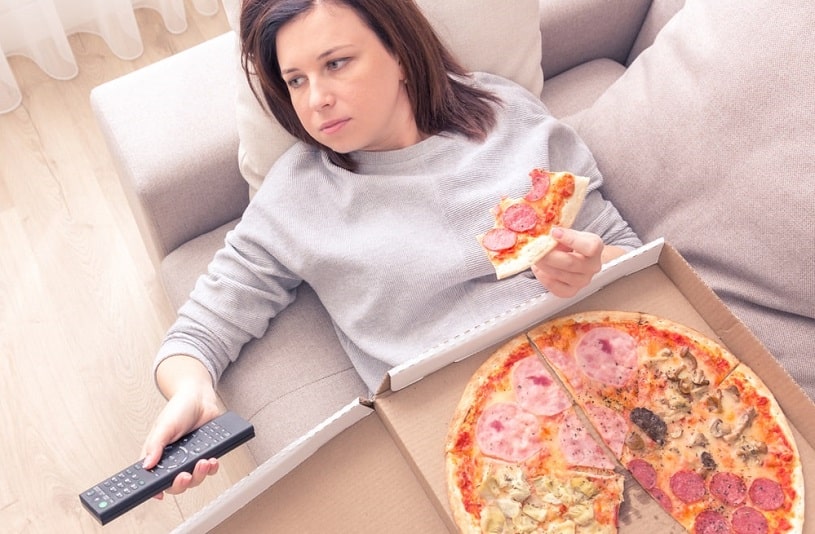 Depressed woman eating pizza.