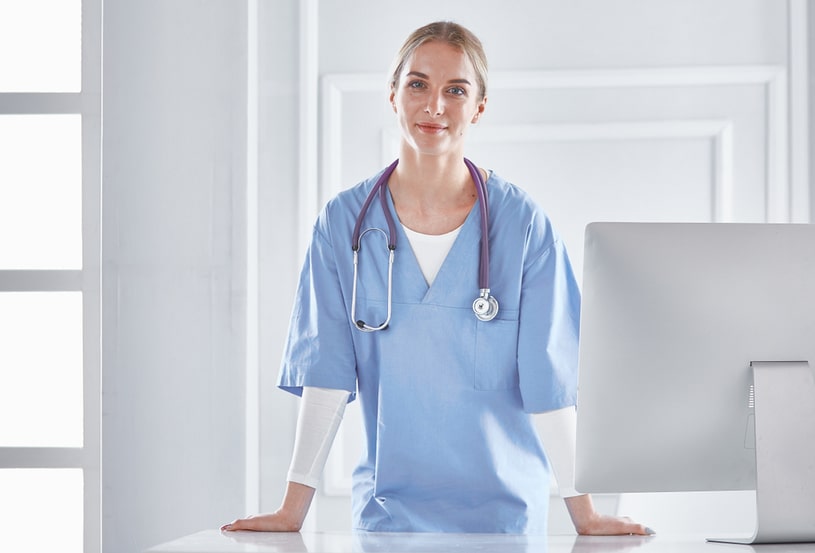 A woman in a doctor's uniform leaned against the table.