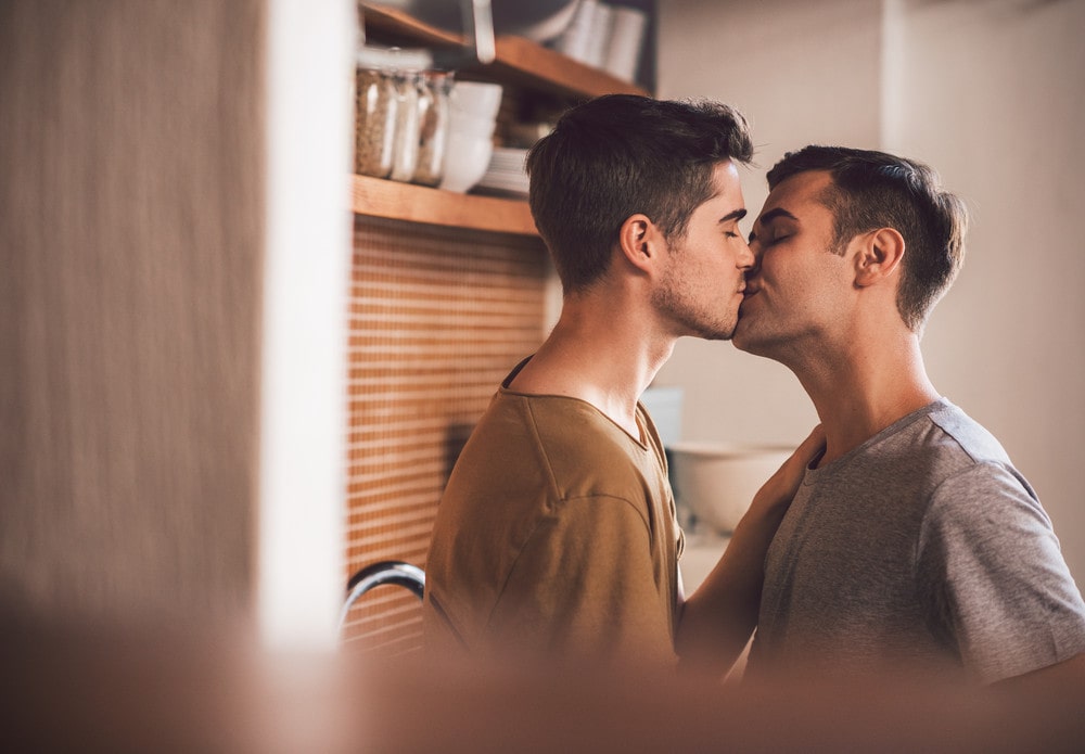 gay couple kissing each other.