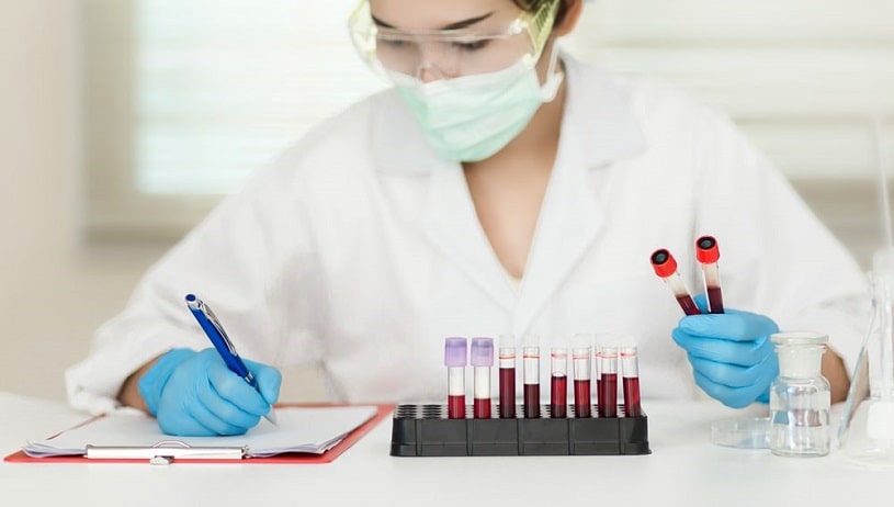 Lab worker holding blood samples.