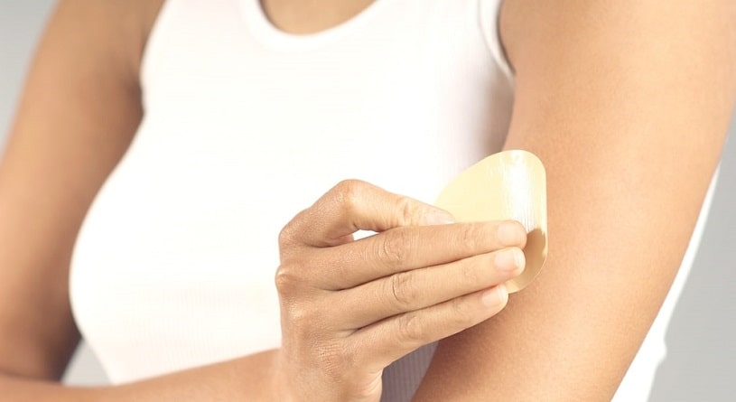 Woman applying a nicotine patch.