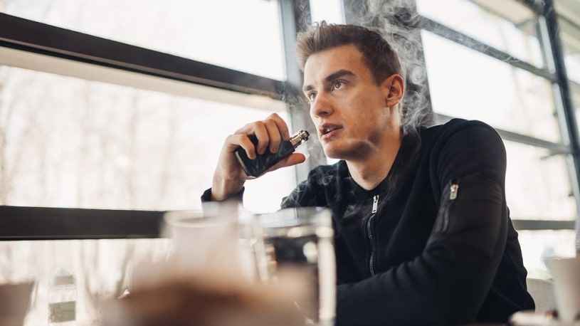 Young man vaping in a public place.