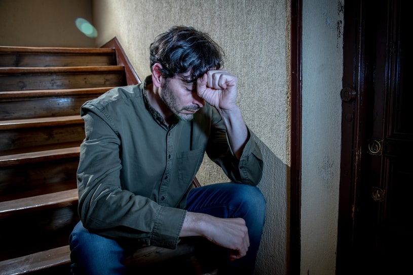 An exhausted man sits on the steps.