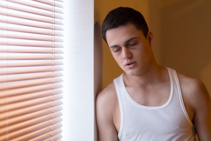 The falling asleep guy stands near the window.