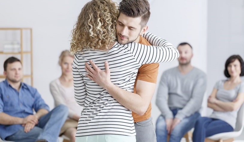 People hugging during support group meeting.