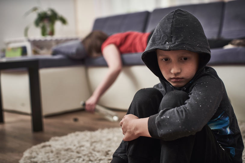 A child sitting near a drunk woman.