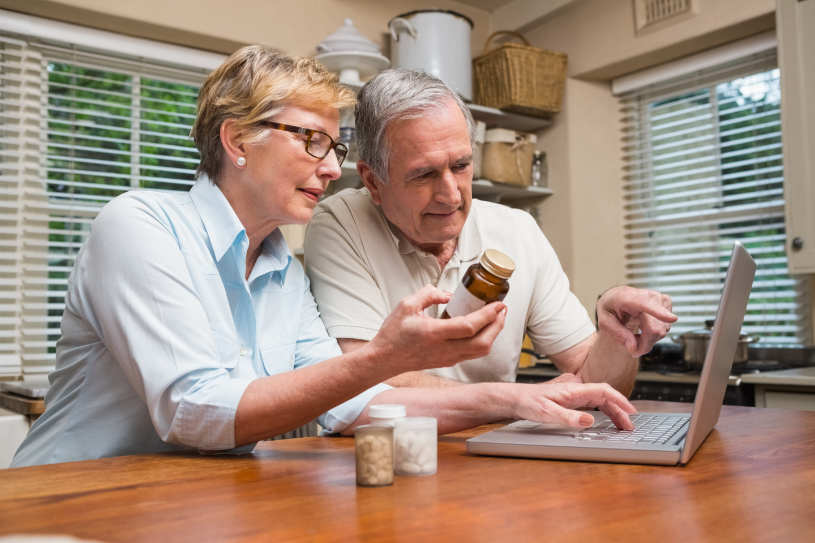 A husband and wife read about Benadryl interactions on their laptop.