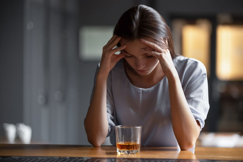 A woman is experiencing health issues due to alcohol abuse and addiction.