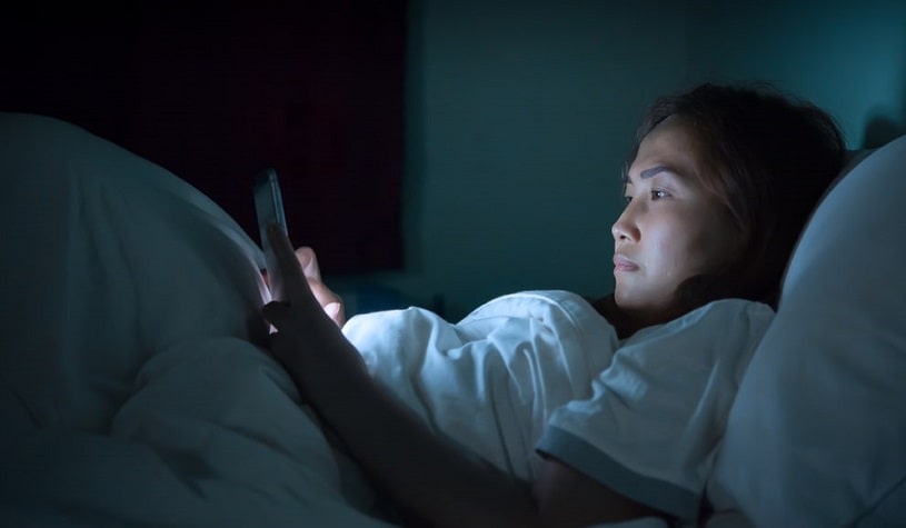 Woman playing smartphone and can't sleep at night.
