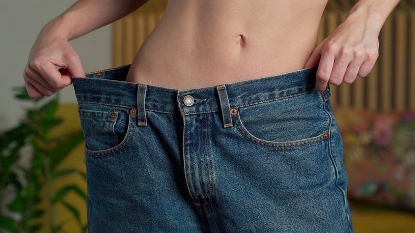 Woman lost weight on Effexor wearing old bigger jeans.