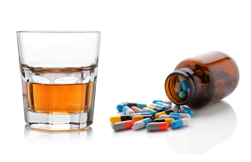 Glass of whisky and antibiotic pills.