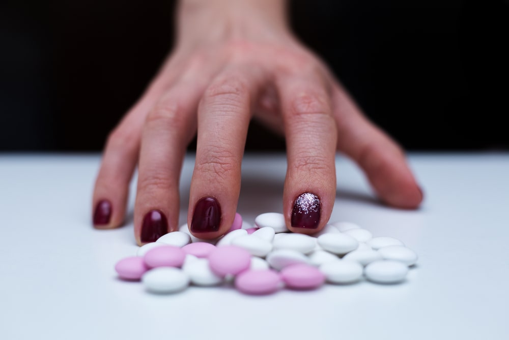 Hand surrounded by Prozac pills.