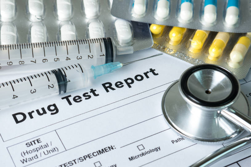 Medications and the drug test result lies on the table.