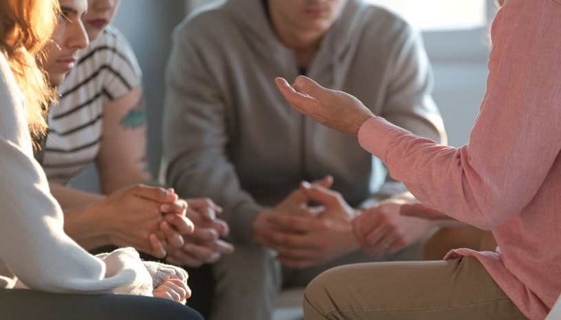 A therapist and a group of people in a rehab.