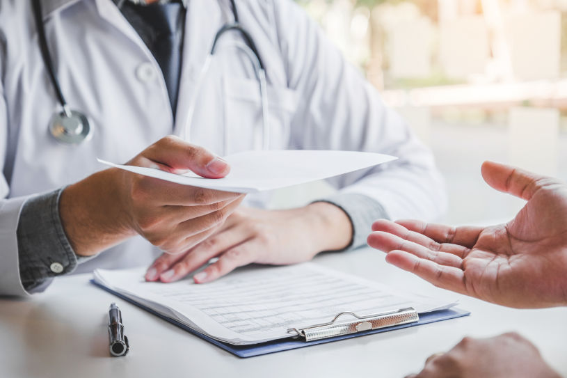 A doctor gives a patient a list of prescriptions.