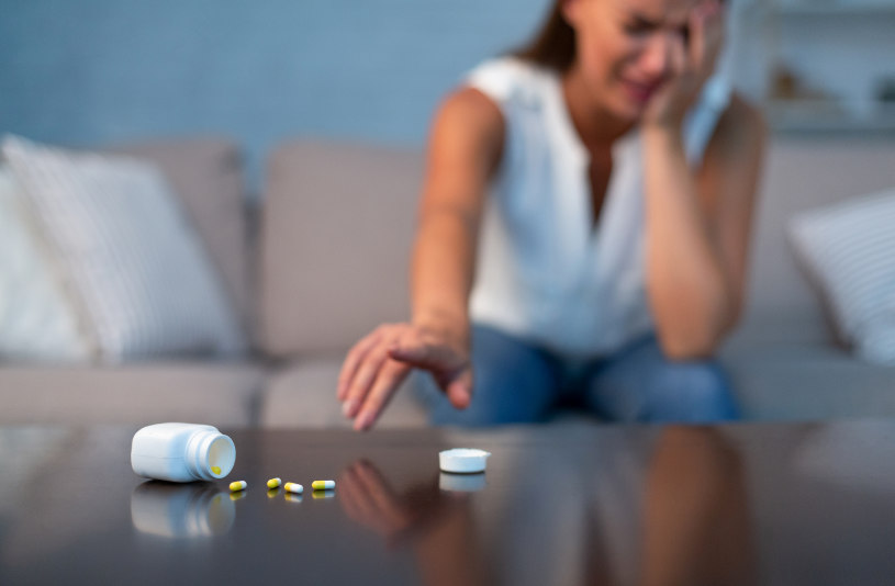 A woman in depression has dropped Viibryd pills on the table.