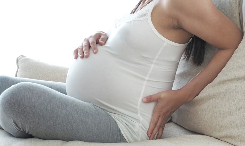 Pregnant woman sitting on the couch.