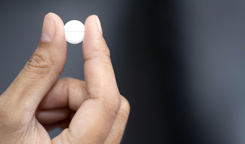 Close up of methadone tablet in hands.