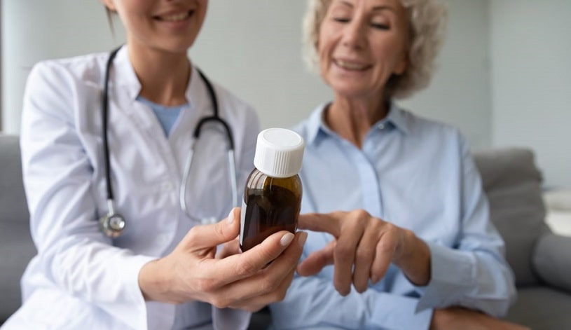 Doctor holding a bottle of pills showing to the patient.