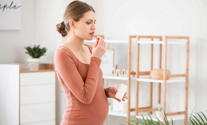 Pregnant woman taking Cymbalta at home.