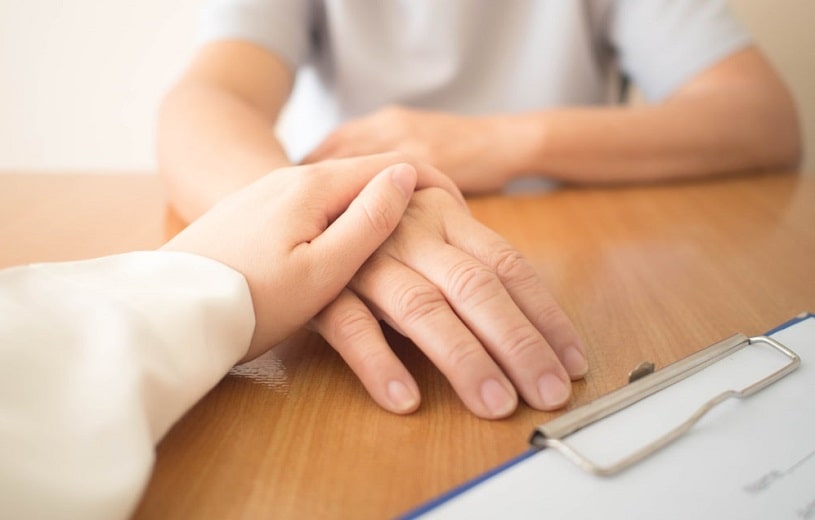 Doctor holding a patient's hand, supporting in Ritalin treatment.